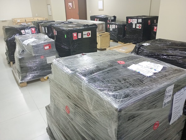 Caixas de equipamentos científicos embaladas e empilhadas em uma sala