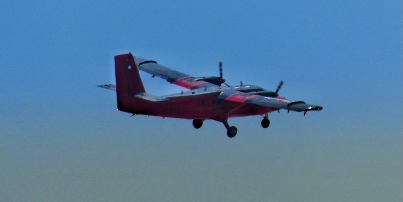 Avião bimotor vermelho em voo